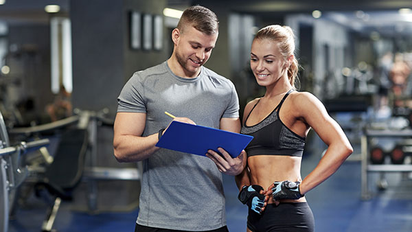 Fitness Trainer zeigt Sportlerin Ihren Ernährungsplan