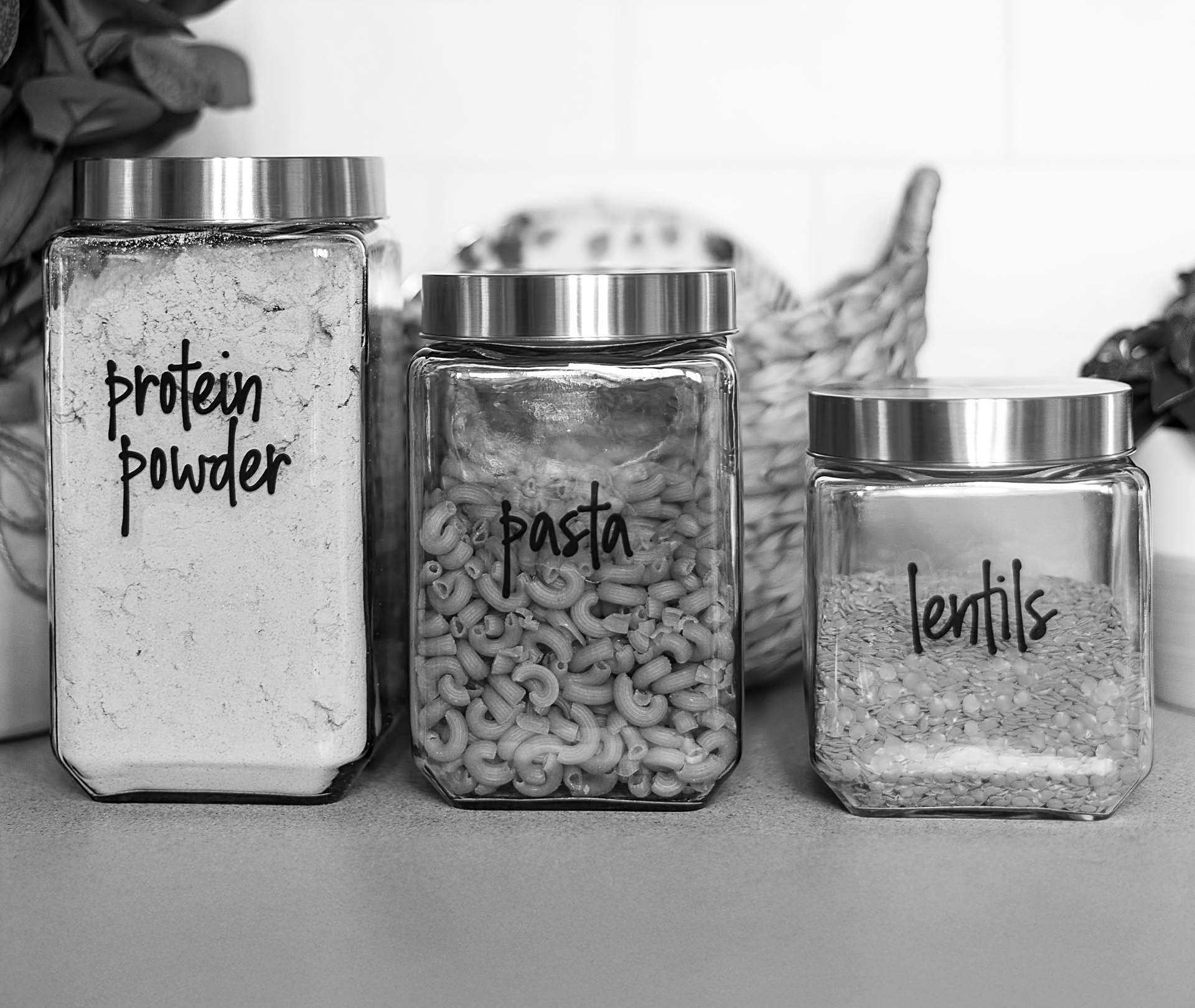 drei Behälter, eins mit Proteinpulver, eins mit Pasta und eins mit Linsen