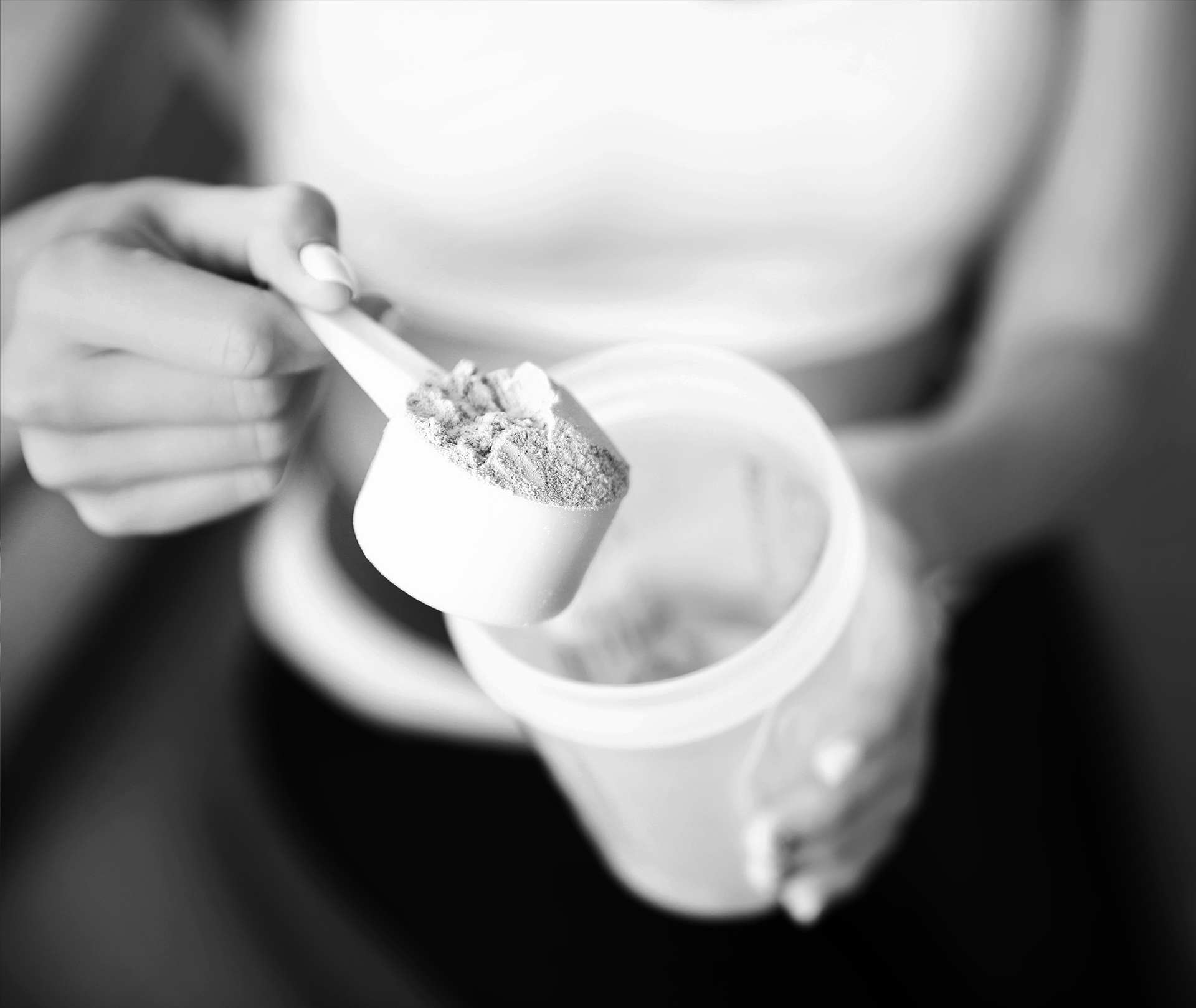 Frau macht einen Scoop Pulver in den Shaker