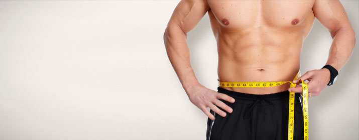 Fitness Model Männlich Oberkörperfrei misst den Bauchumfang