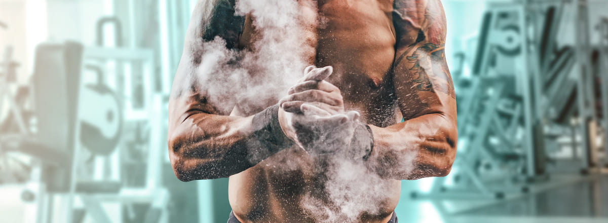 Männlicher Fitness Sportler klatscht mit Puder in die Hände