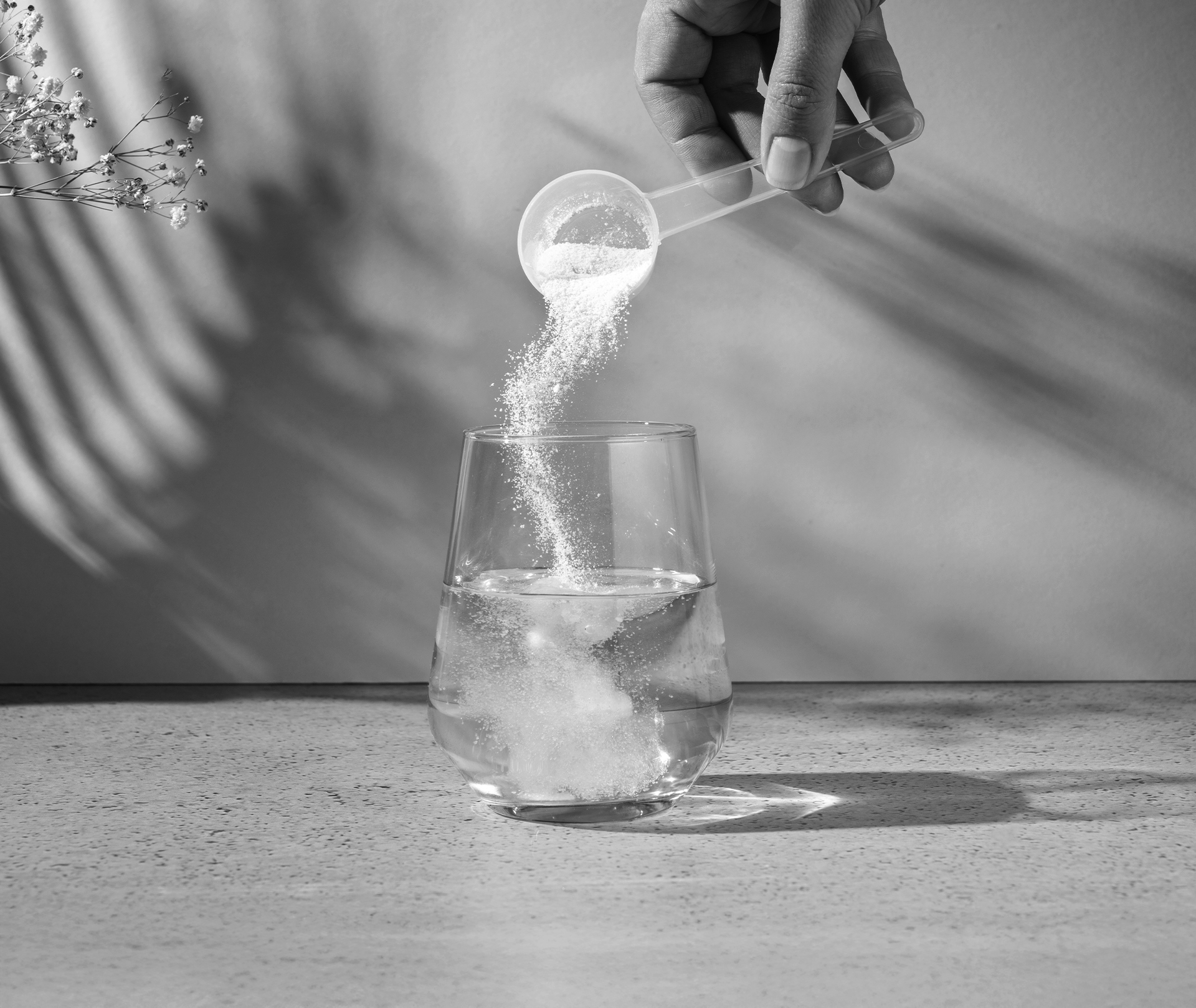 Wasserglas wird mit einem Scoop Pulver befüllt.