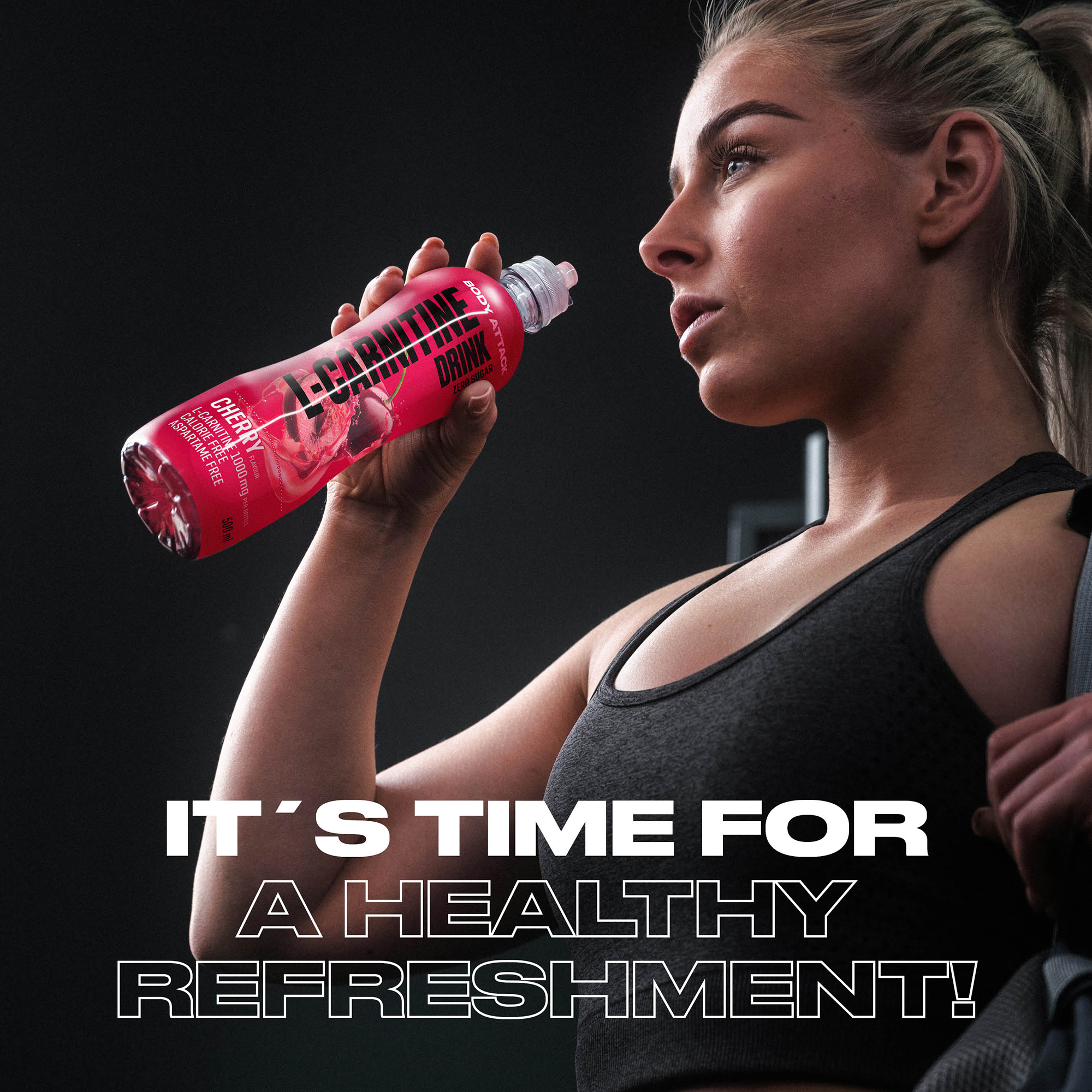 Eine Sportlerin trinkt einen L-Carnitine Drink Cherry