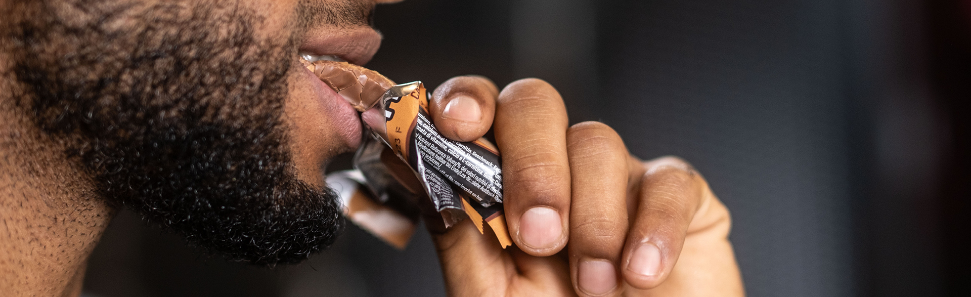 Ein Mann isst einen Proteinriegel