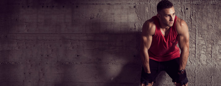 Sportler lehnt sich erschöpft an eine Wand an